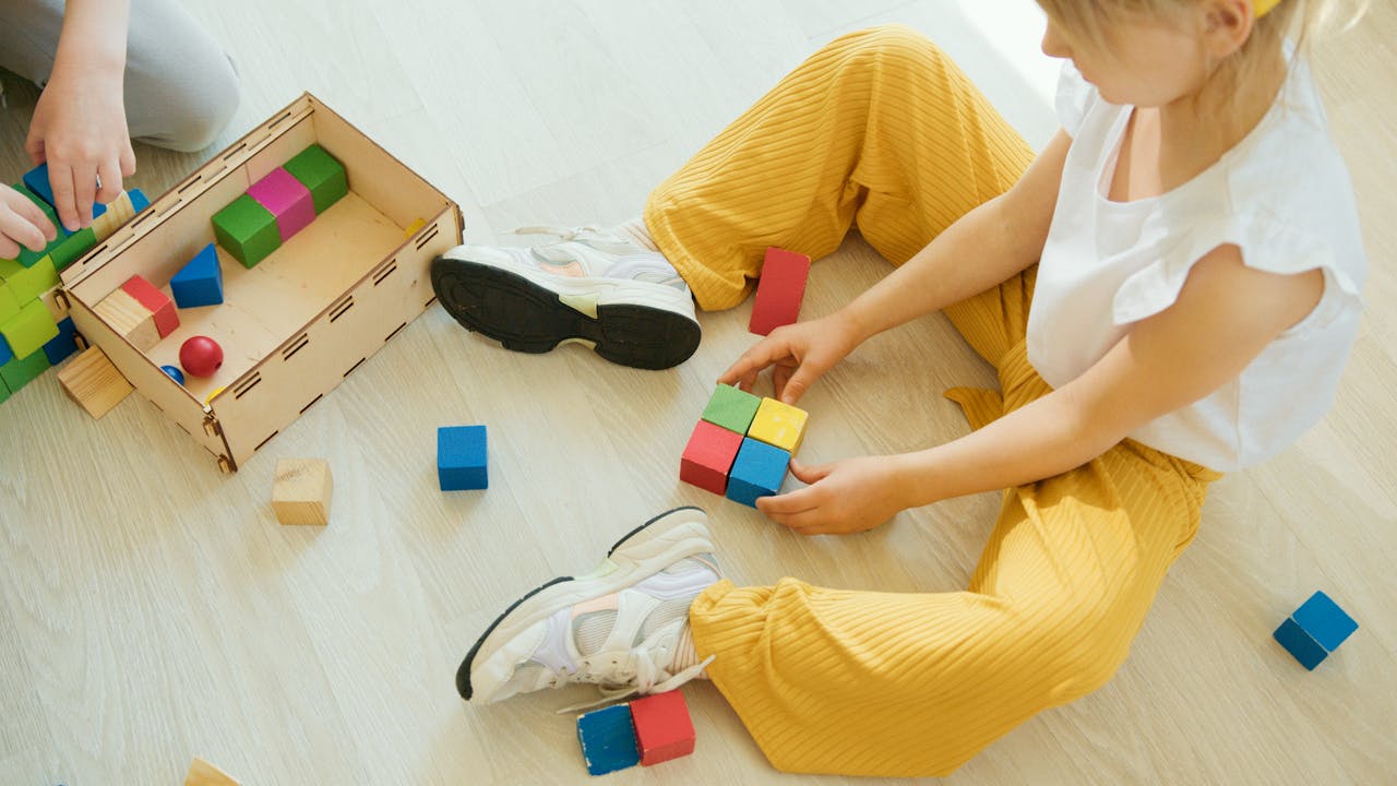 High-Angle Shot of Girl Playing Wooden Blocks